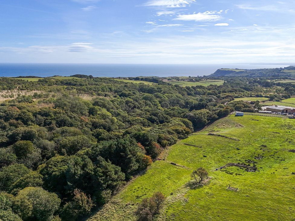 A coastal landscape with fields and trees at Stable Cottage in Staintondale