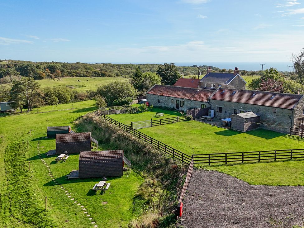 An outdoor area with cabins and picnic tables at Stable Cottage in Staintondale
