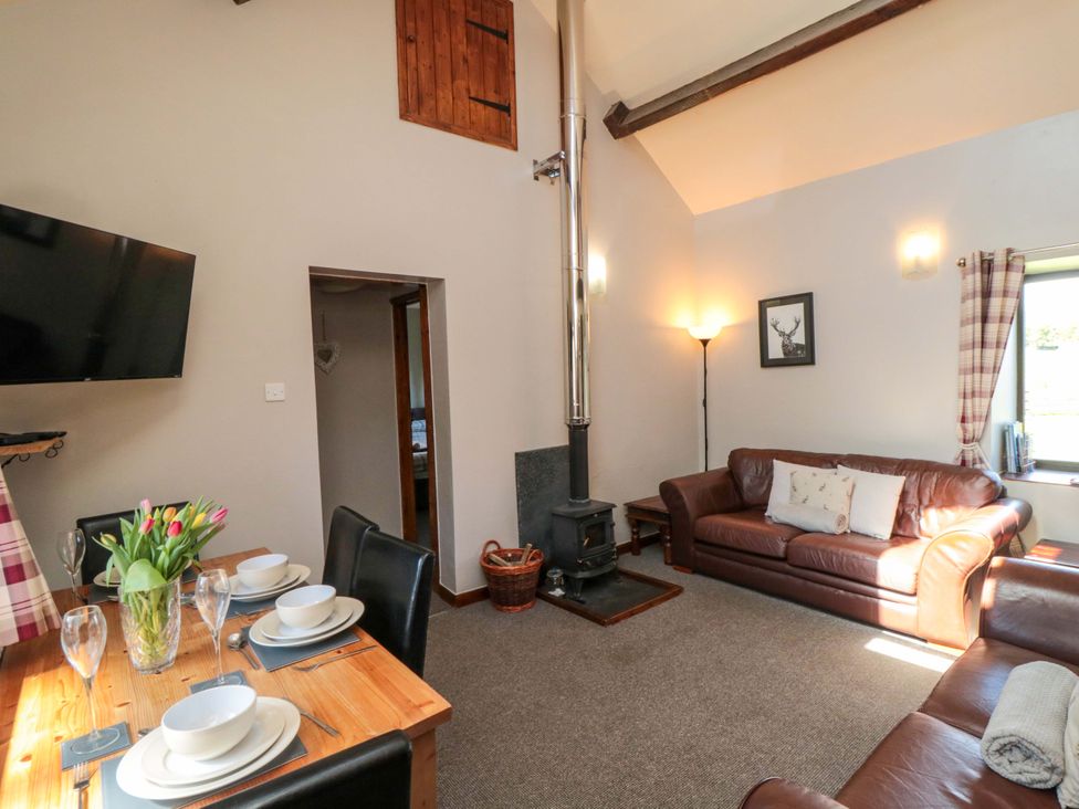 A living room with a dining area and seating at Stable Cottage in Staintondale near Burniston