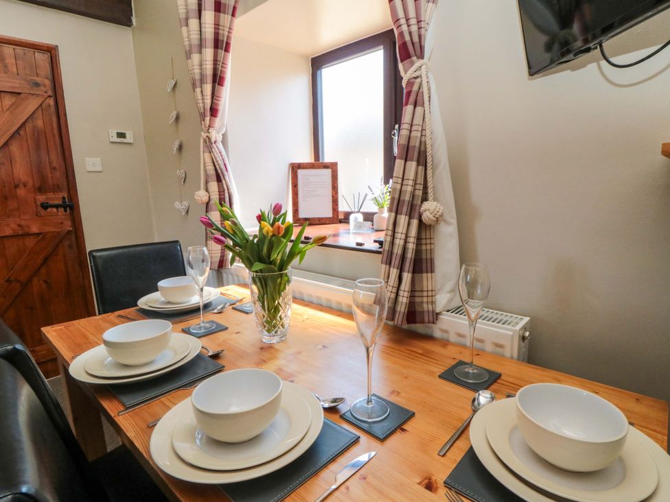A dining room with a wooden table set at Stable Cottage in Staintondale near Burniston