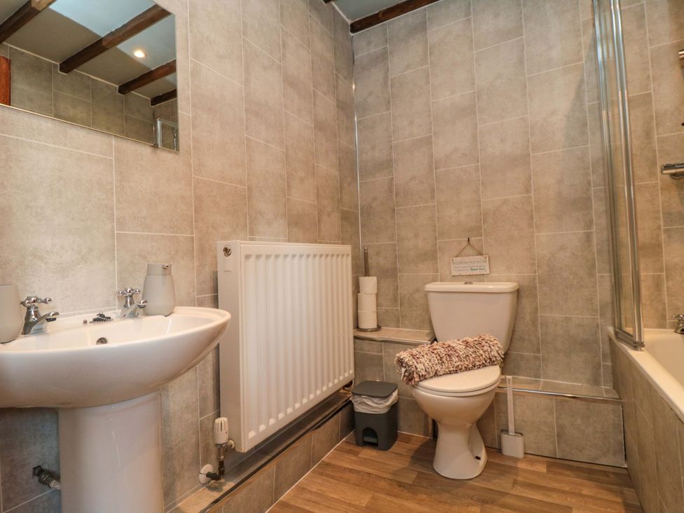 A bathroom with sink, toilet, and bathtub at Stable Cottage Staintondale near Burniston