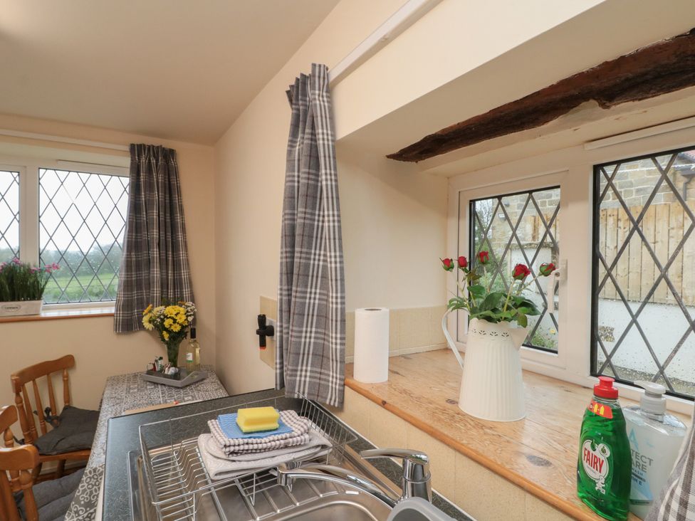 A kitchen with a sink and flowers on the countertop at Foxhunter Cottage Hawsker near Whitby and Robin Hood's Bay