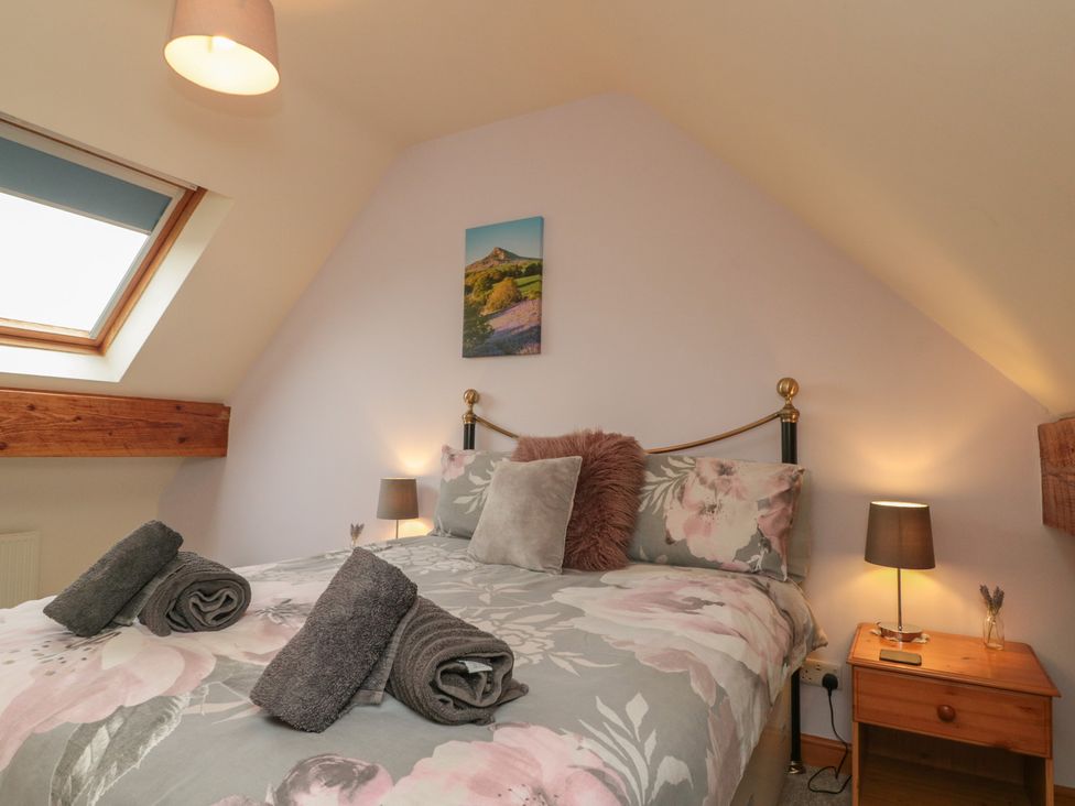 A bedroom with a bed and lamp at Foxhunter Cottage, Hawsker near Whitby and Robin Hood's Bay
