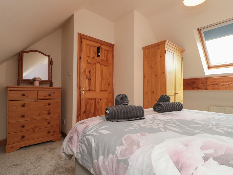 A bedroom with a bed and dresser at Foxhunter Cottage in Hawsker near Whitby and Robin Hood's Bay