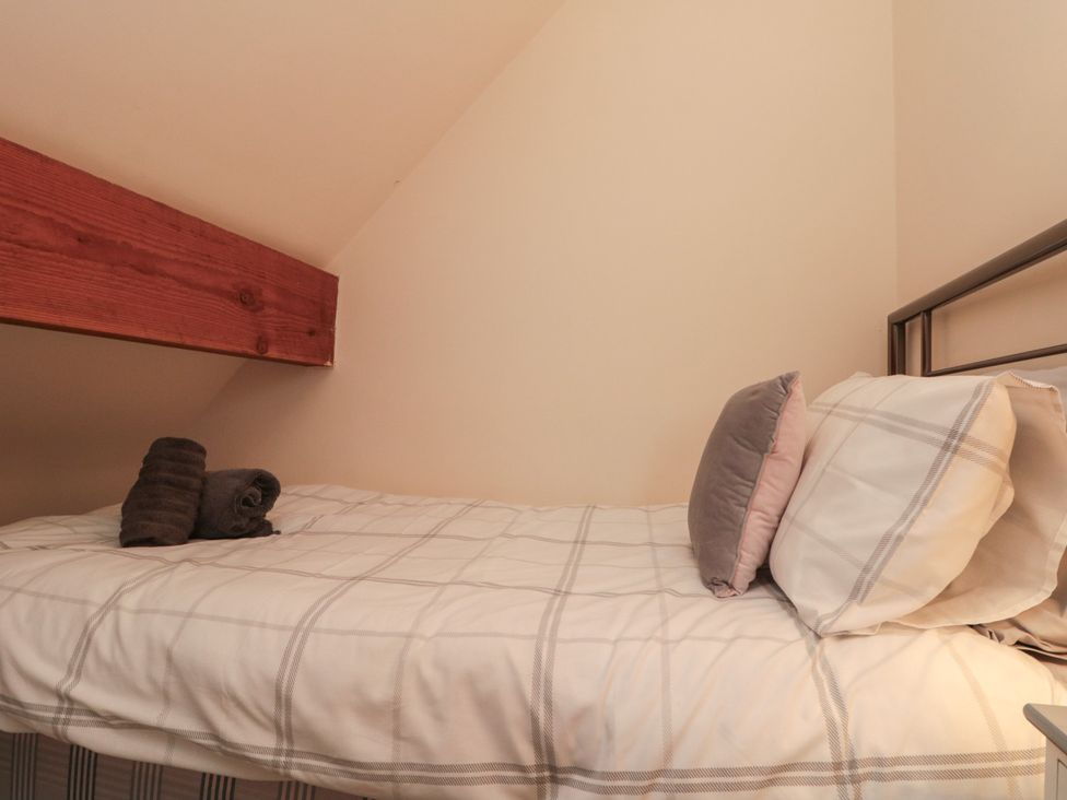 A bedroom with a bed and towels at Foxhunter Cottage Hawsker near Whitby and Robin Hood's Bay