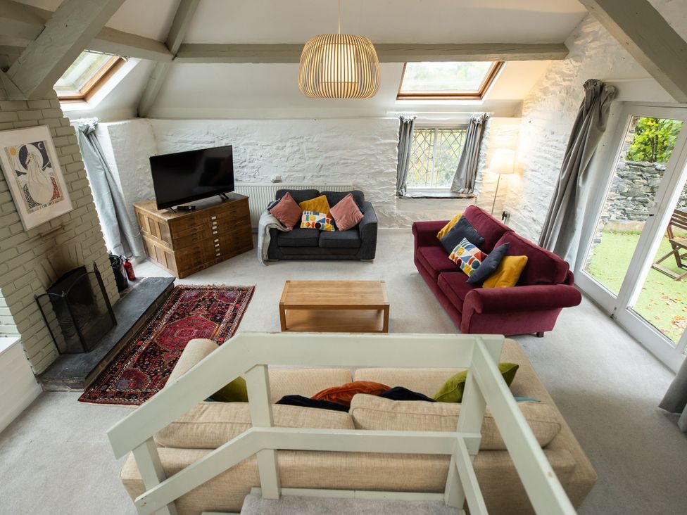 A living room with sofas and a television at The Coach House in Llangollen