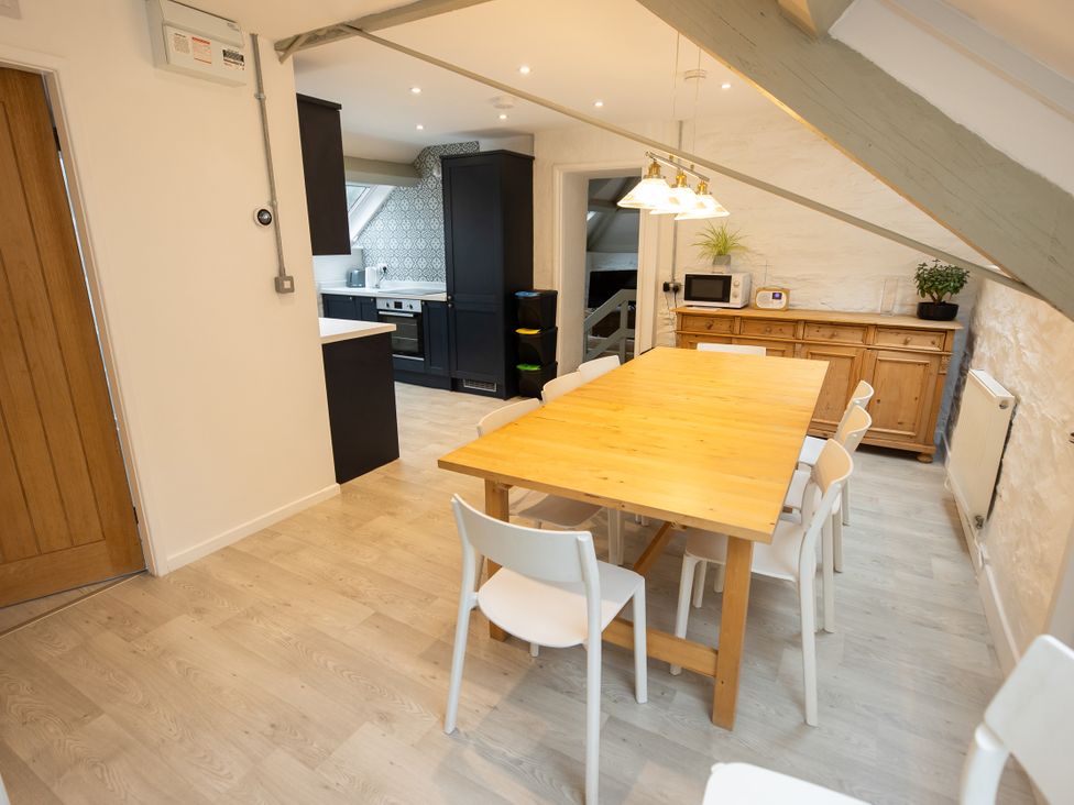 A dining room with a wooden table and chairs at The Coach House in Llangollen