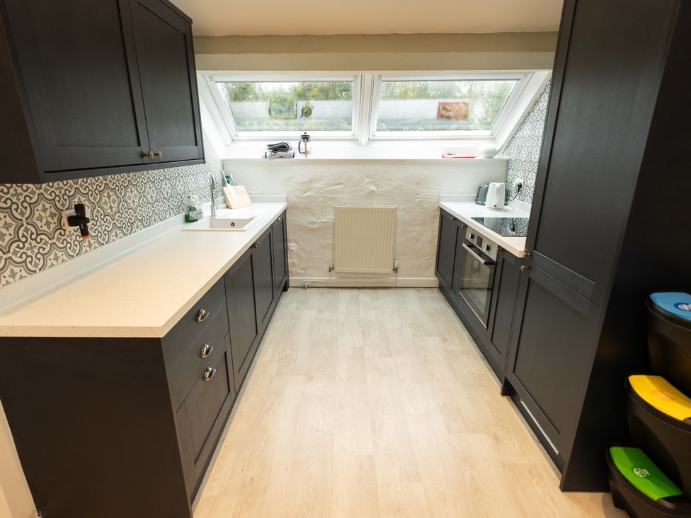 A kitchen with cabinets and appliances at The Coach House Llangollen