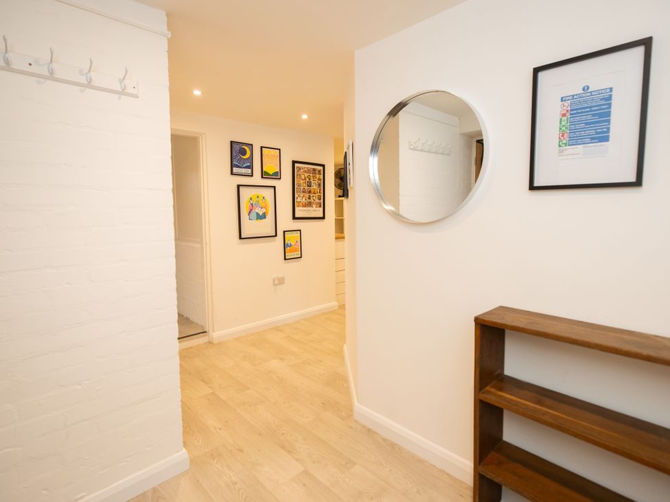 A hallway with hooks on the wall and framed pictures at The Coach House in Llangollen