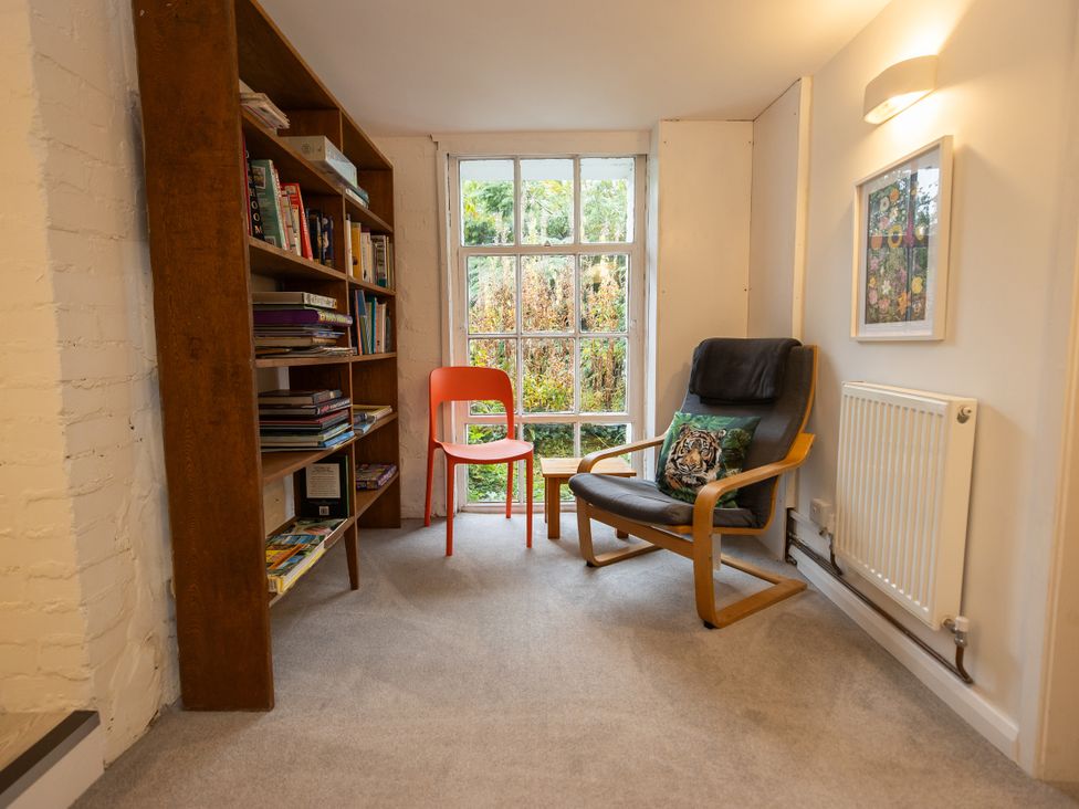 A reading room with a bookshelf and seating area at The Coach House in Llangollen