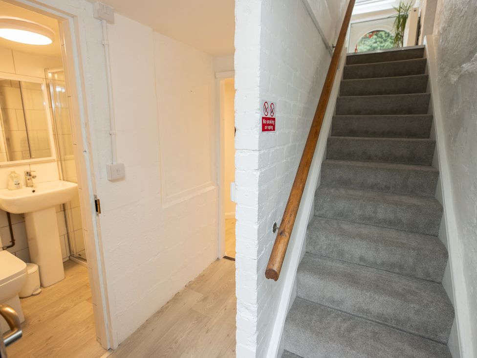 A staircase leading up with a bathroom visible at The Coach House in Llangollen