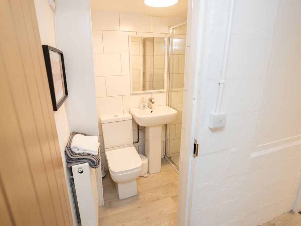 A bathroom with a sink, toilet, and shower at The Coach House in Llangollen
