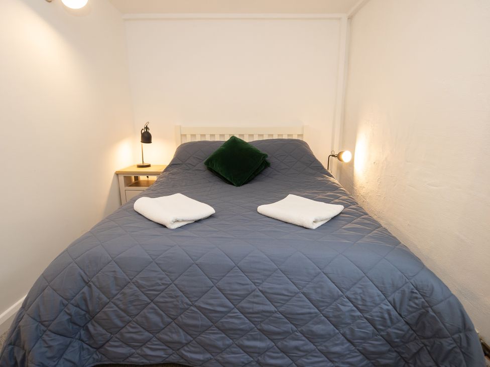 A bedroom with a bed and bedside table at The Coach House Llangollen