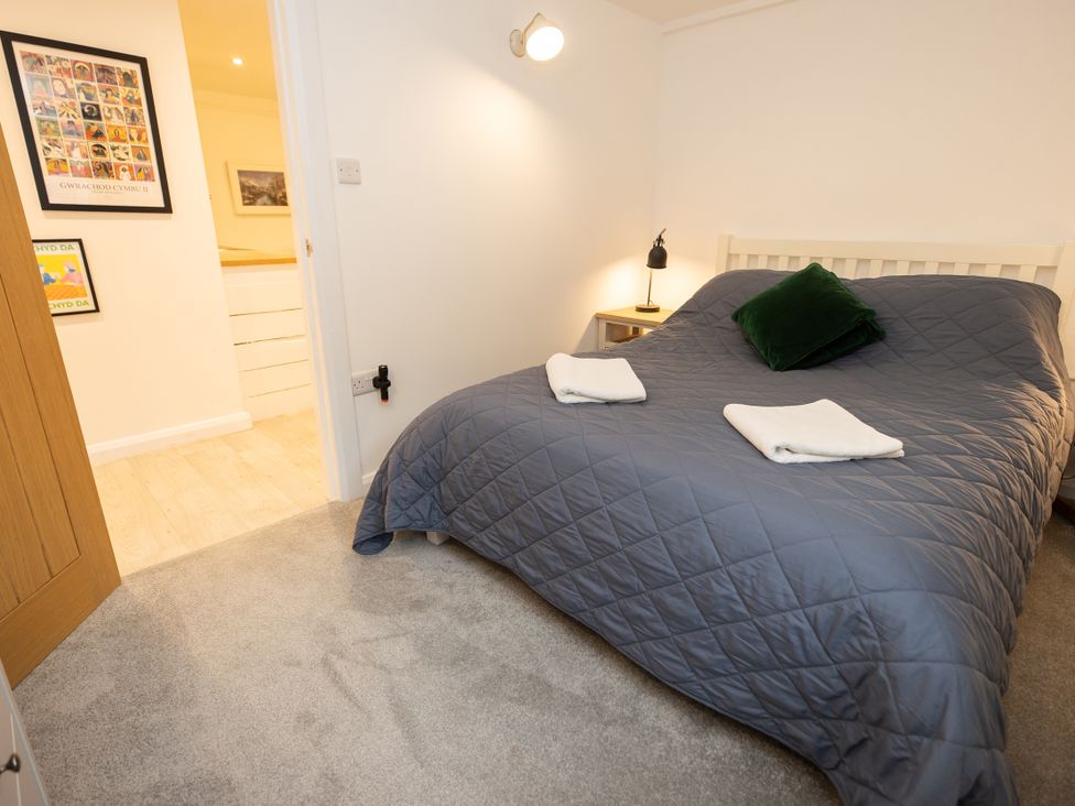 A bedroom with a bed and bedside table at The Coach House in Llangollen