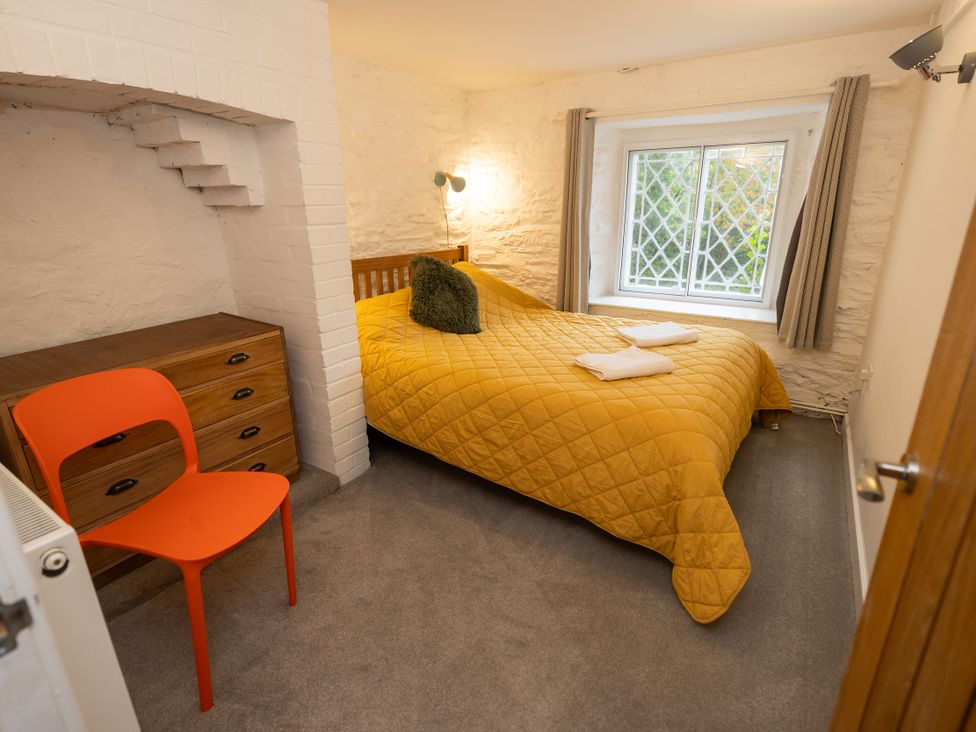 A bedroom with a bed and dresser at The Coach House in Llangollen