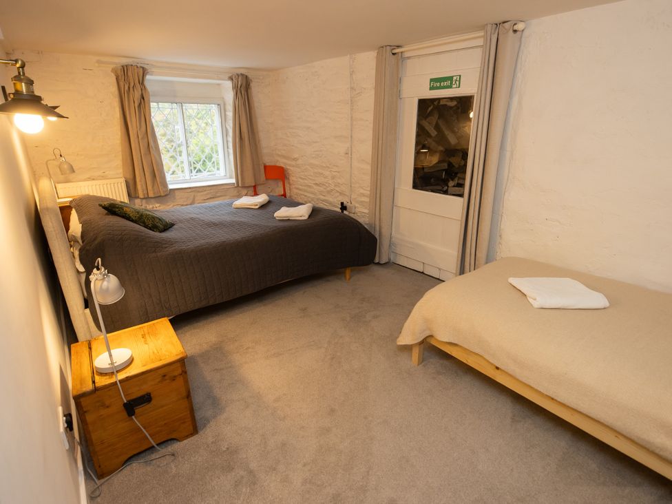 A bedroom with two beds and a window at The Coach House in Llangollen