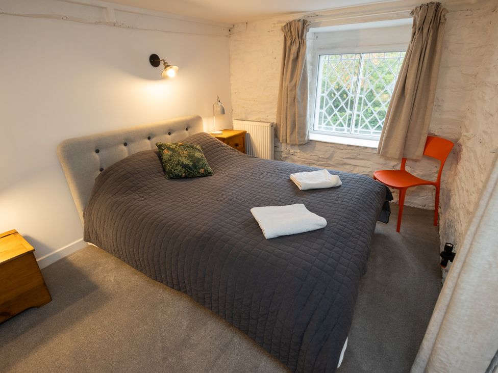 A bedroom with a bed and window at The Coach House in Llangollen