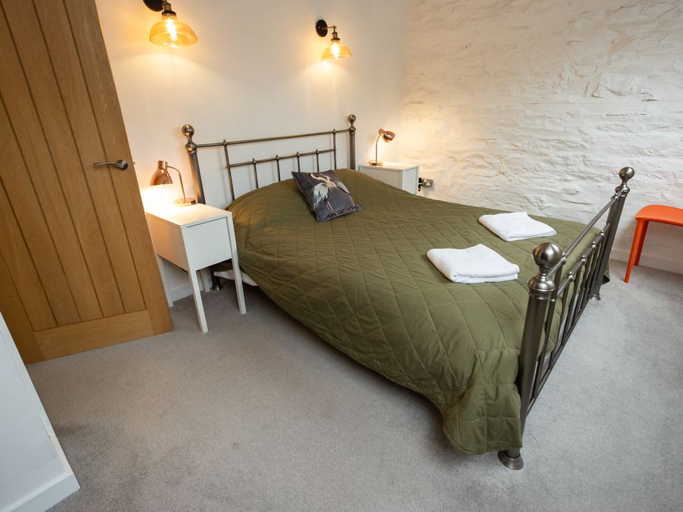A bedroom with a bed and nightstands at The Coach House Llangollen