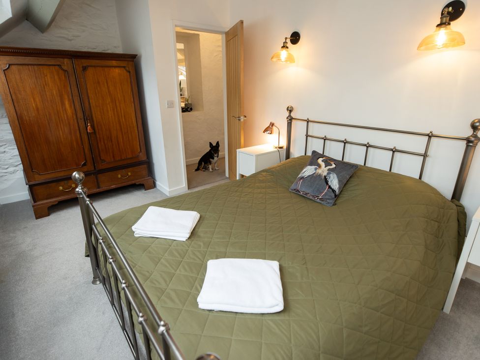 A bedroom with a bed and wardrobe at The Coach House in Llangollen