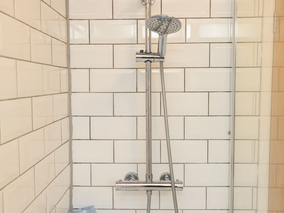 A shower with chrome fixtures in a bathroom at The Coach House in Llangollen