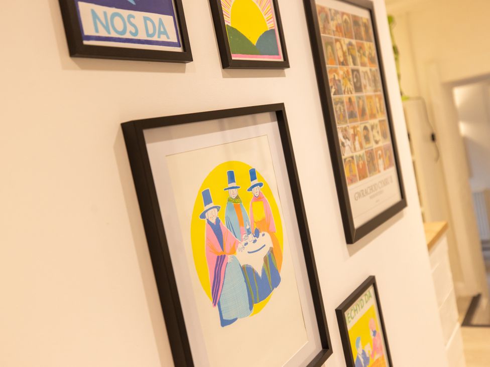 A wall with framed artwork at The Coach House in Llangollen