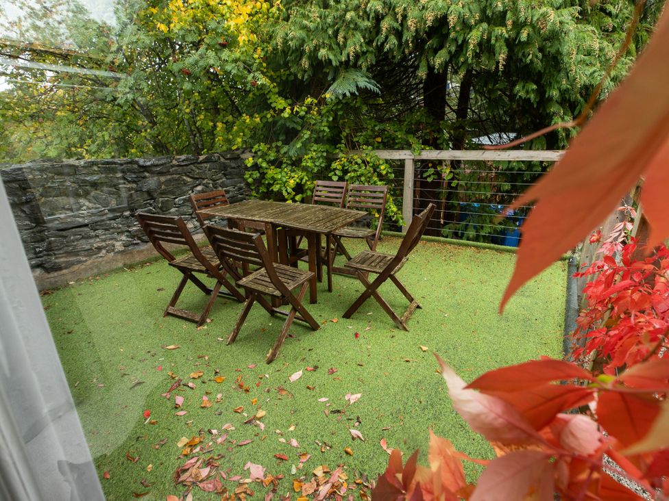 An outdoor seating area with a table and chairs at The Coach House in Llangollen