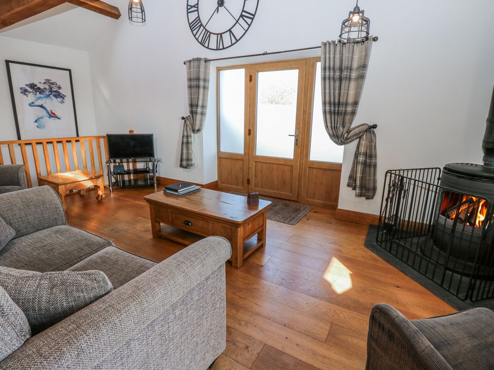 A living room with a sofa and television at Apple Tree Cottage in Bleatarn near Kirkby Stephen