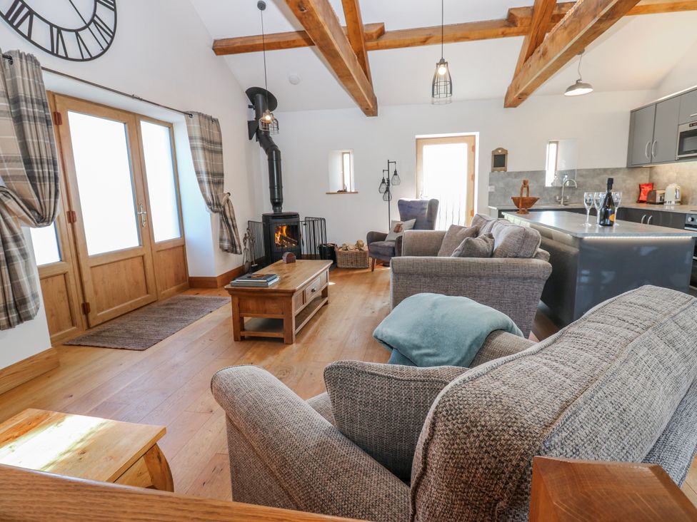 A living room with a fireplace and sofas at Apple Tree Cottage Bleatarn near Kirkby Stephen