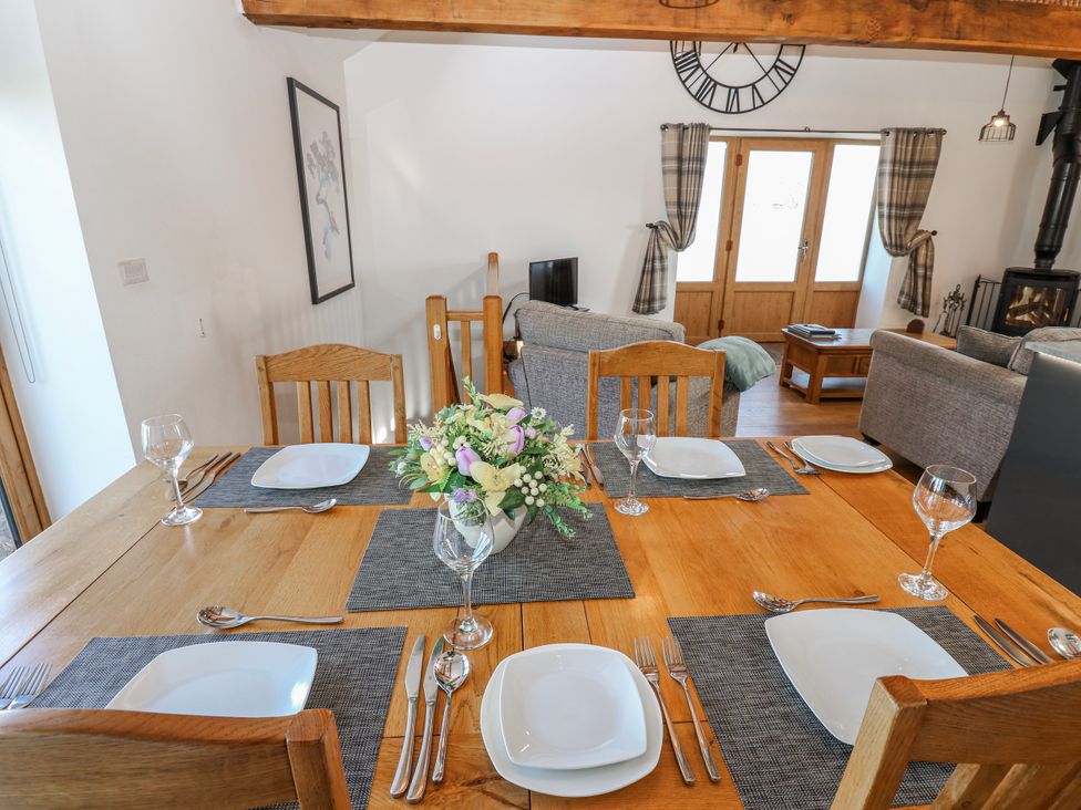 A dining room with a wooden table set for dinner at Apple Tree Cottage Bleatarn near Kirkby Stephen
