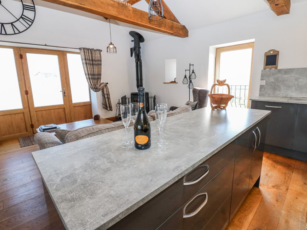A kitchen with a champagne bottle and glasses on a counter at Apple Tree Cottage Bleatarn near Kirkby Stephen