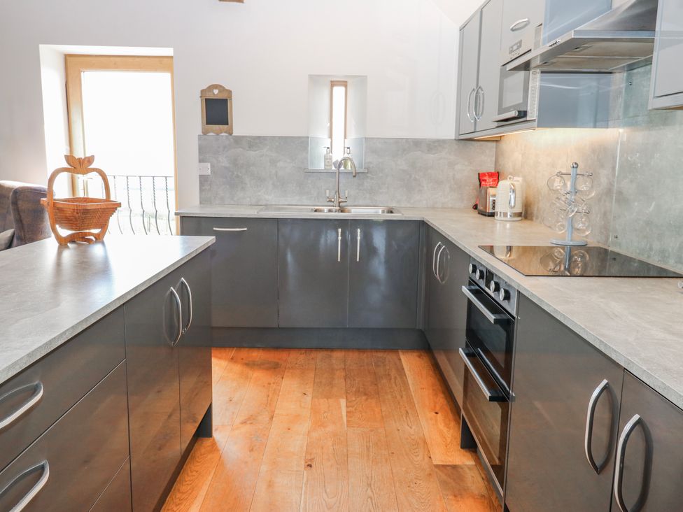 A kitchen with cabinets and a sink at Apple Tree Cottage in Bleatarn near Kirkby Stephen
