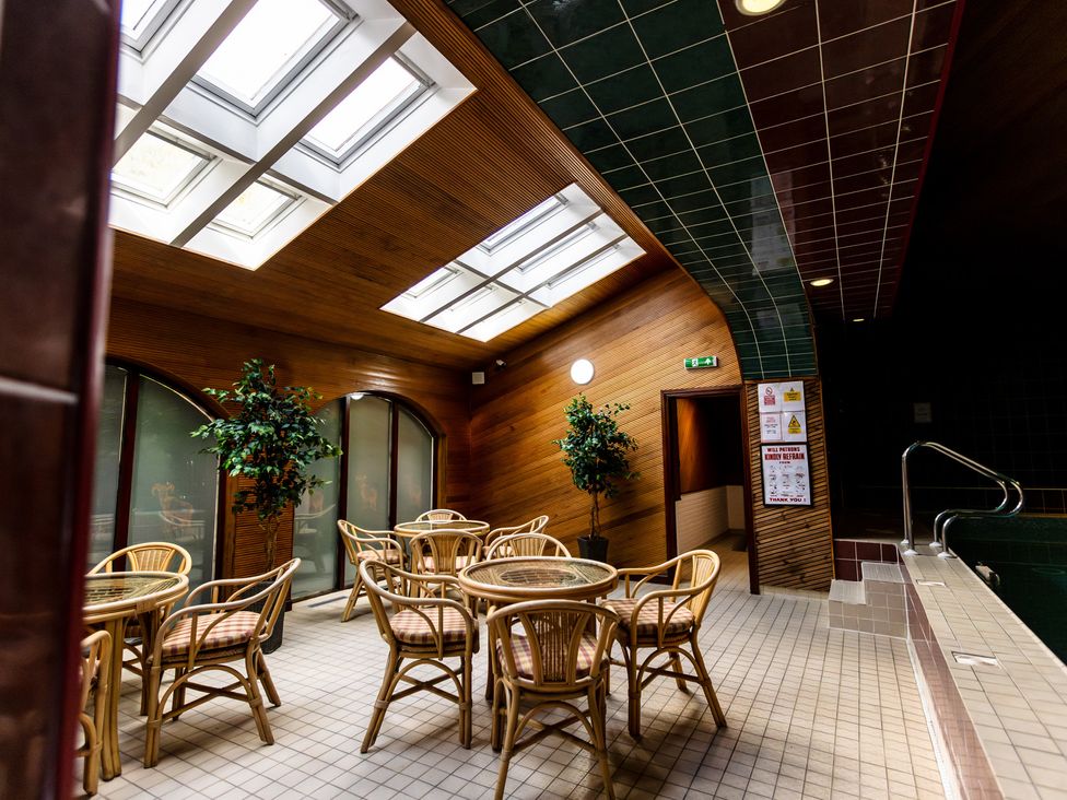 An indoor pool area with tables and chairs at Bracken Lodge in Wooler