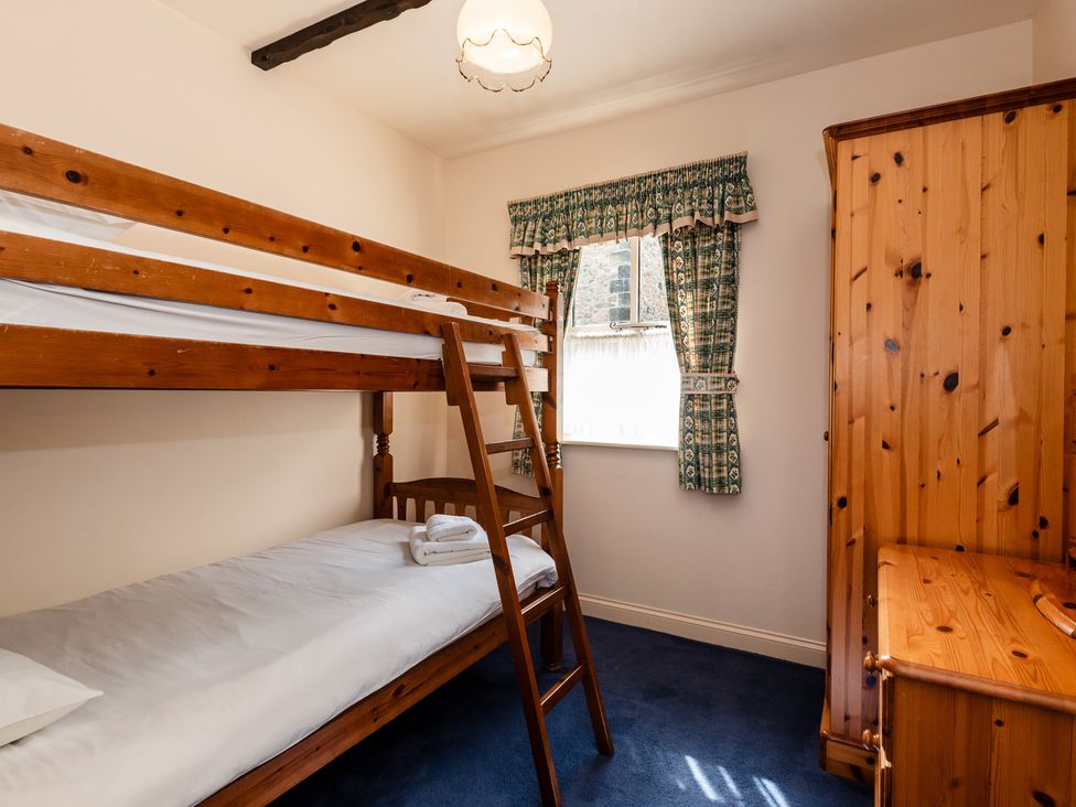 A bedroom with a bunk bed and wardrobe at Blueberry Cottage in Akeld near Wooler