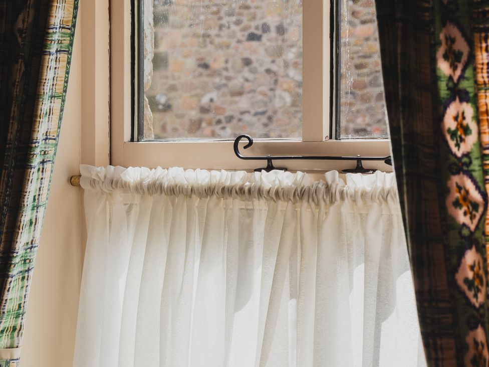 A window with sheer curtains at Blueberry Cottage in Akeld near Wooler