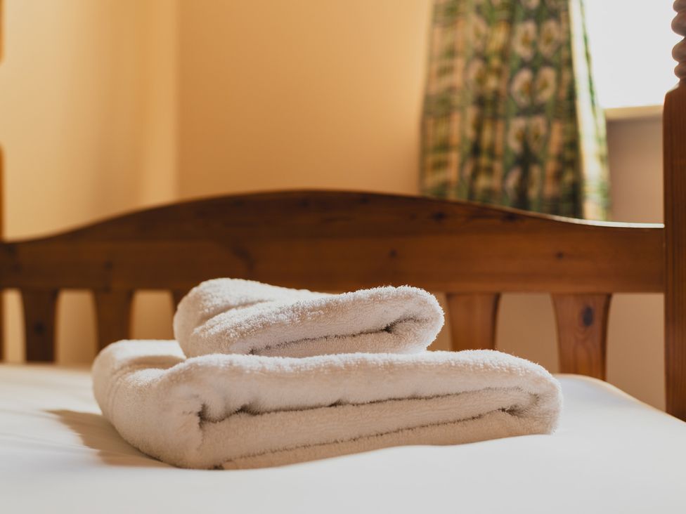A bed with towels on top at Blueberry Cottage in Akeld near Wooler