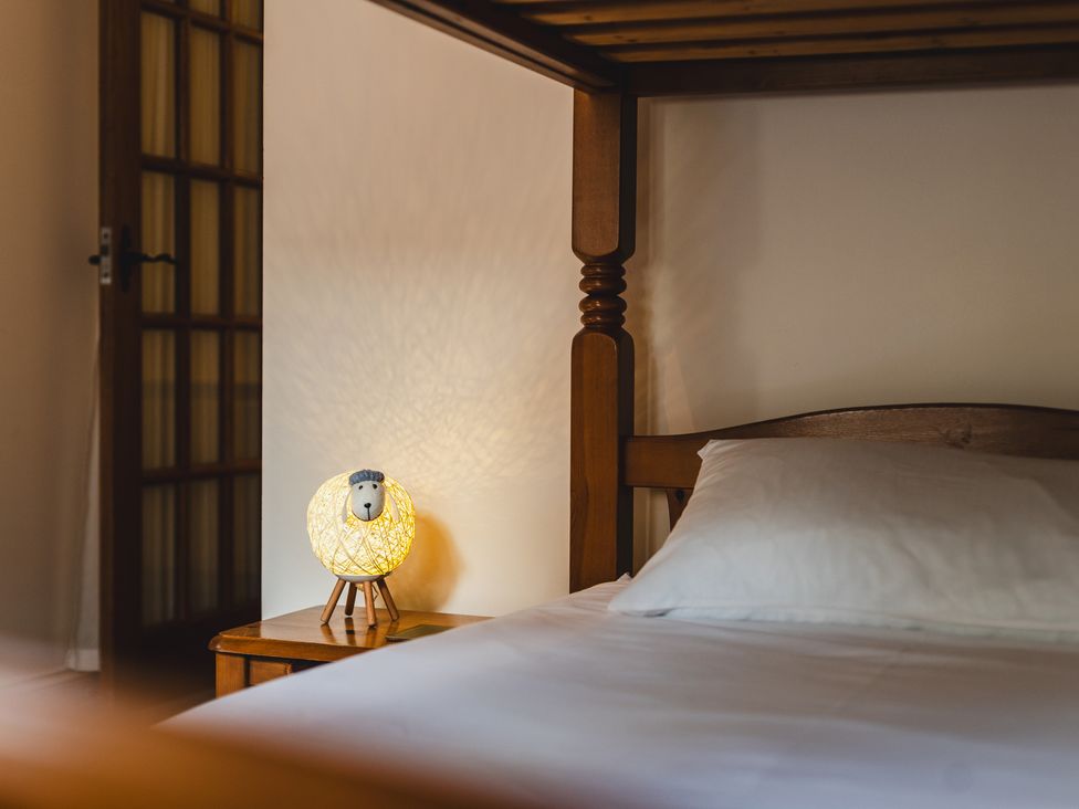 A bedroom with a bed and a lamp on the nightstand at Blueberry Cottage in Akeld near Wooler