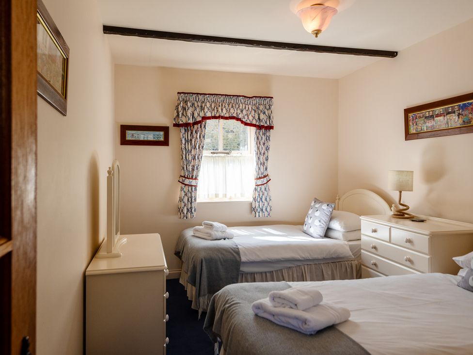 A bedroom with two beds and a dresser at Blueberry Cottage in Akeld near Wooler