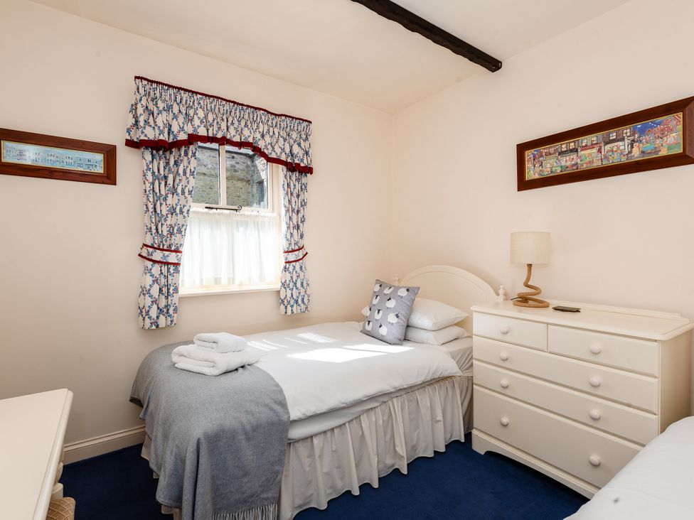 A bedroom with two beds and a dresser at Blueberry Cottage in Akeld near Wooler