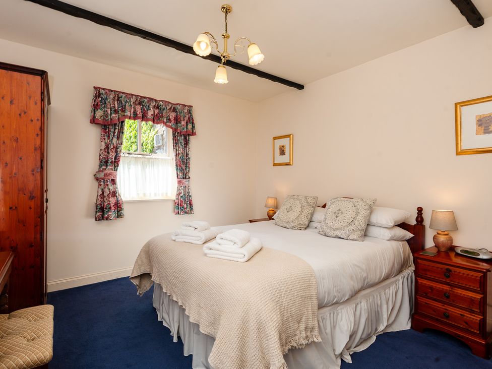 A bedroom with a bed and wardrobe at Blueberry Cottage Akeld near Wooler