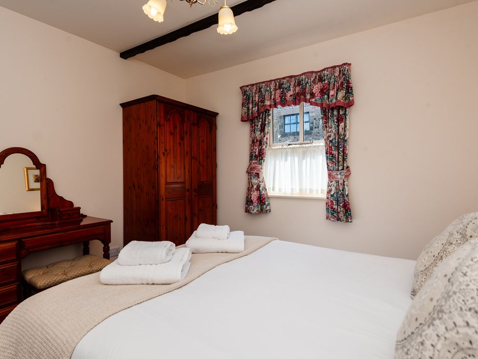 A bedroom with a bed and wardrobe at Blueberry Cottage in Akeld near Wooler