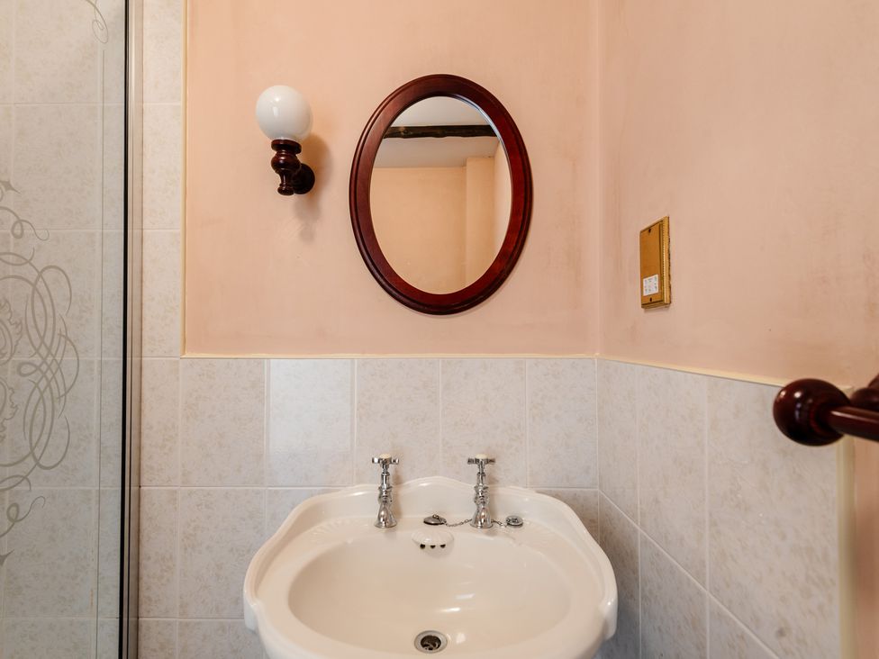 A bathroom with a wash basin and mirror at Blueberry Cottage Akeld near Wooler