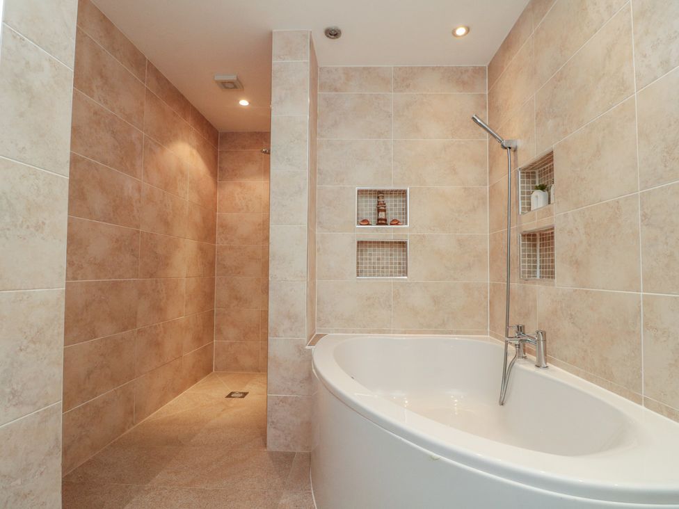 A bathroom with a bathtub and shower area at Apartment 6 in Whitby