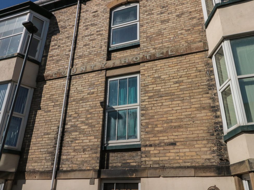A building facade with a hotel sign and multiple windows at Apartment 6 in Whitby