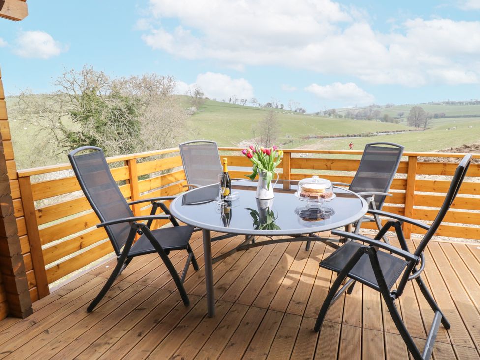 An outdoor seating area with a table and chairs at Manor Farm Lodges - Red Kite Lodge in Newtown