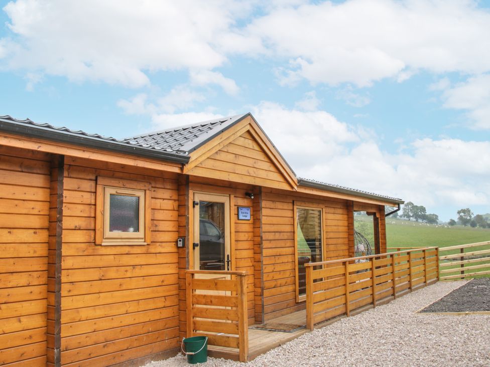 An outdoor view of a wooden lodge at Manor Farm Lodges - Red Kite Lodge in Newtown