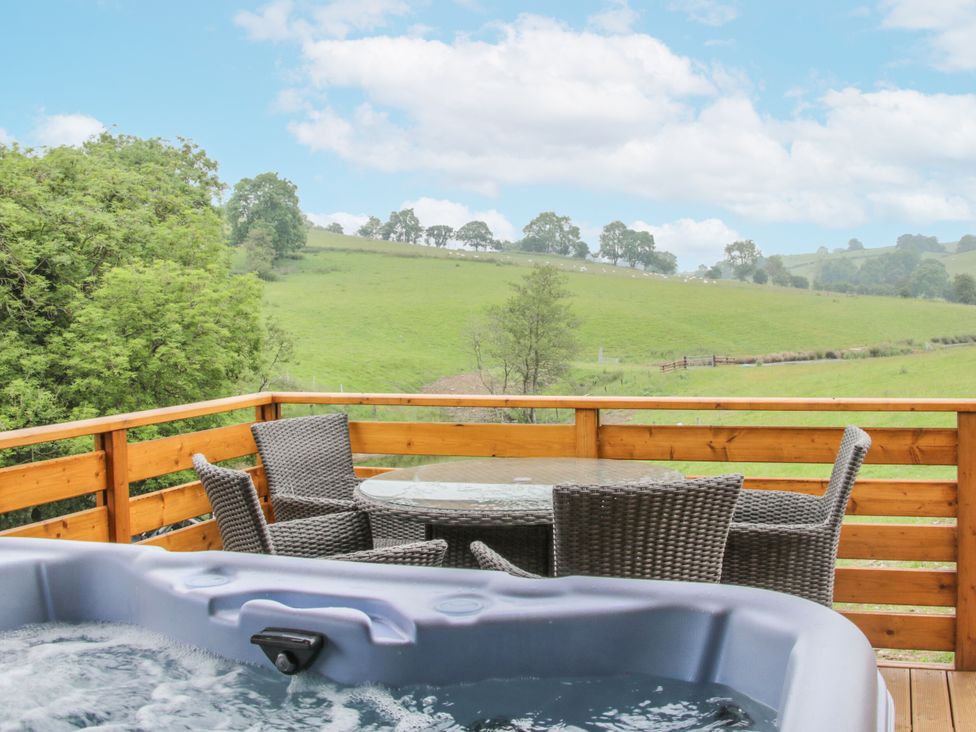 A balcony with a hot tub and outdoor furniture at Manor Farm Lodges - Red Kite Lodge in Newtown