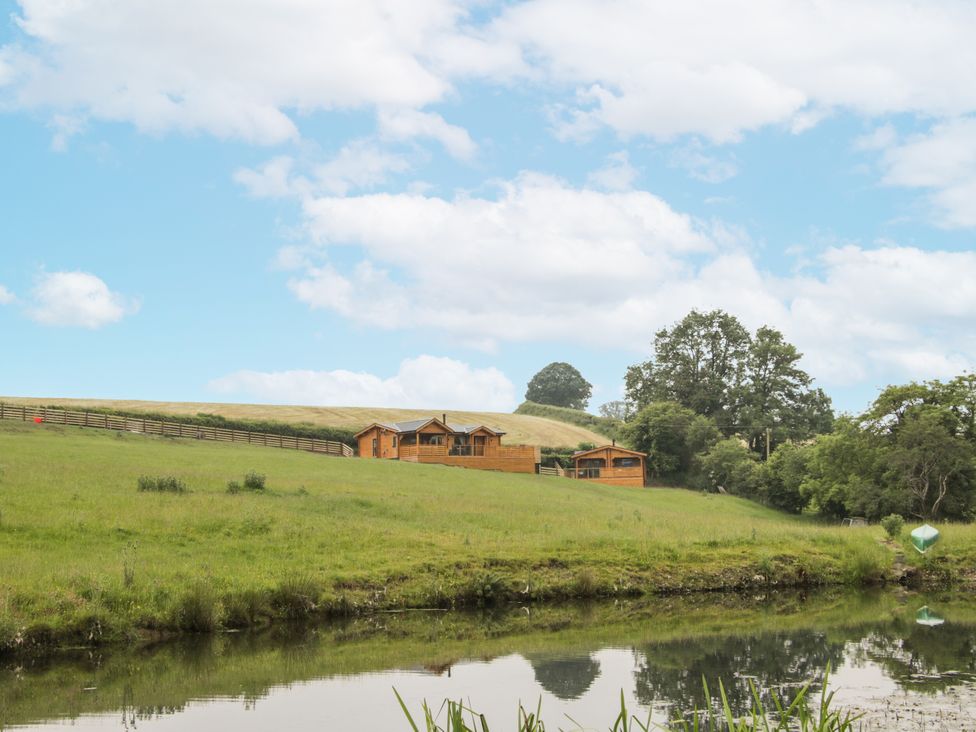 A view of lodges and water in an outdoor area at Manor Farm Lodges - Red Kite Lodge in Newtown