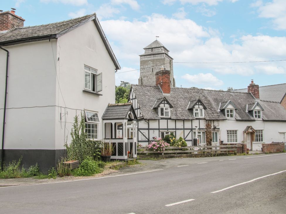 A view of houses along a road with a tower in the background at Manor Farm Lodges - Red Kite Lodge in Newtown