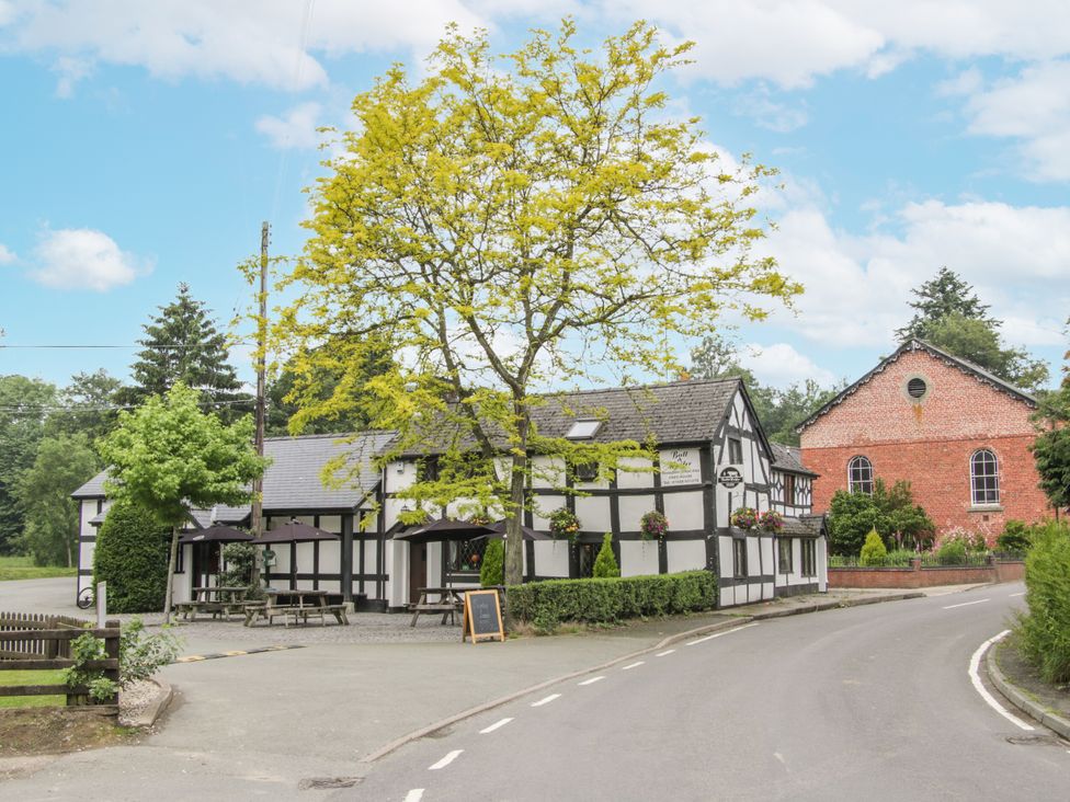 A building with outdoor seating and trees at Manor Farm Lodges - Dragon Lodge in Newtown