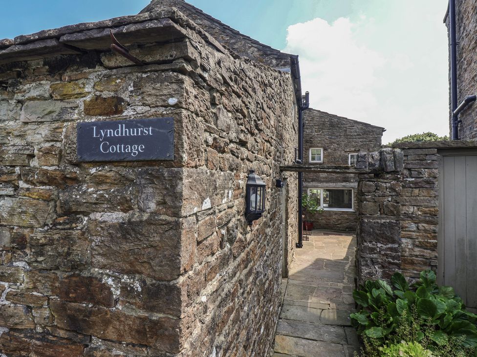 An outdoor pathway with stone walls and a lantern at Lyndhurst Cottage in Carlton-in-Coverdale near Leyburn